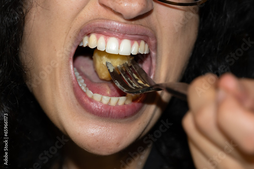 Bouche d'une femme en gros plan en train de manger avec une fourchette photo
