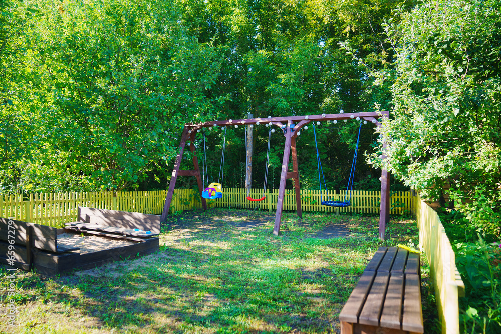 lawn with playground in the garden. sandbox, swings and benches. lawn with playground in the garden. sandbox, swings and benches.