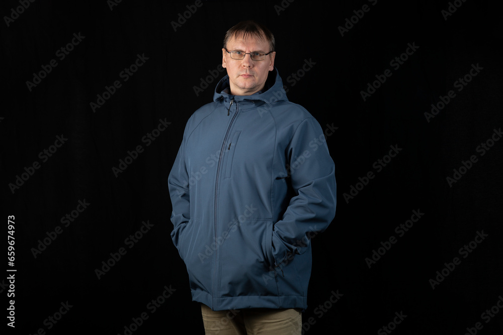 Sale of jackets for the spring and autumn period. A man in a jacket on a dark background.