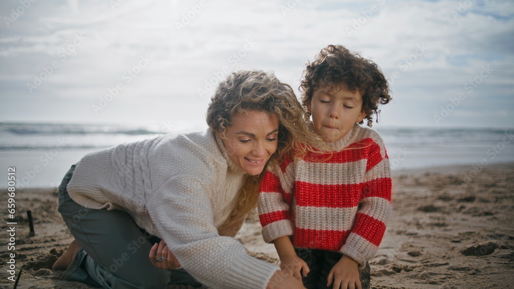 Mom kid playing sand beach closeup. Smiling parent having fun kissing cute son Mom kid playing sand beach closeup. Smiling parent having fun kissing cute son