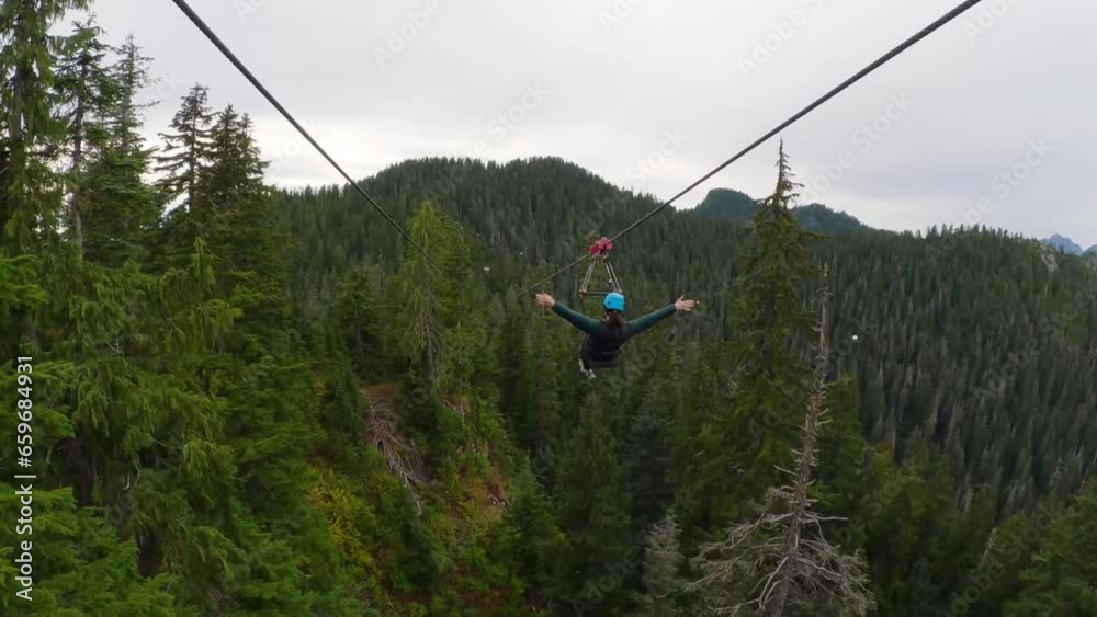 Adventure Woman riding on a Zipline. Extreme Fun Activity.