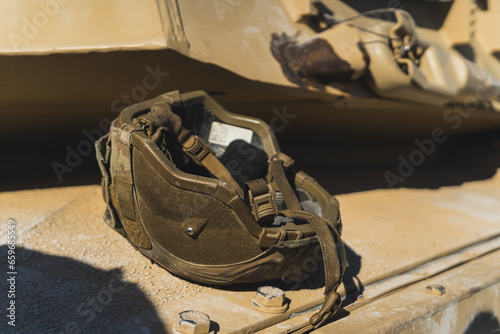 Dark-coloured military helmet lying upside down on a military US tank. Modern military equipment. High quality photo photo