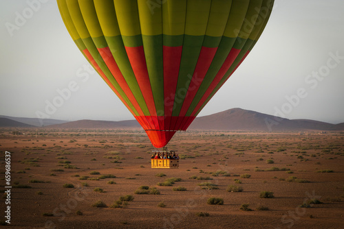 Hot balloon flying at sunset over the Atlas Mountains in the desert of Morocco 