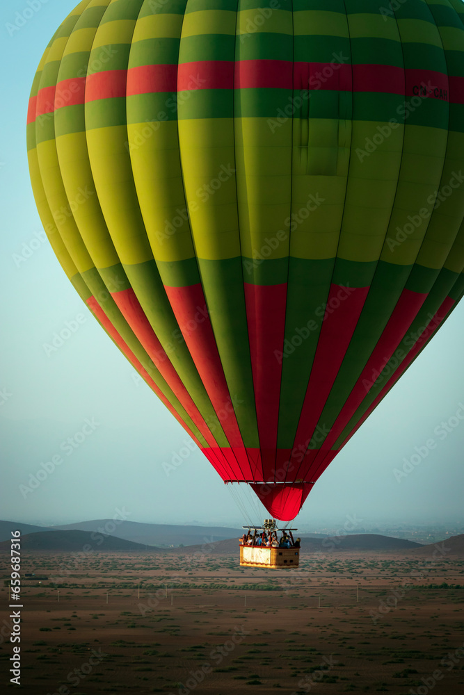 Obraz premium Hot balloon flying at sunset over the Atlas Mountains in the desert of Morocco