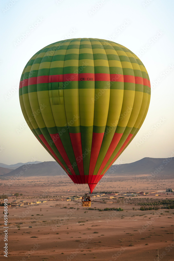 Obraz premium Hot balloon flying at sunset over the Atlas Mountains in the desert of Morocco