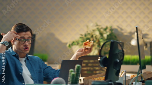 Laughing men lunch break in office closeup. Designers enjoying pizza having fun