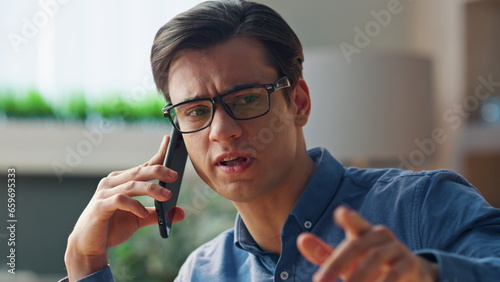 Closeup serious freelancer talking mobile phone office. Manager telephone call