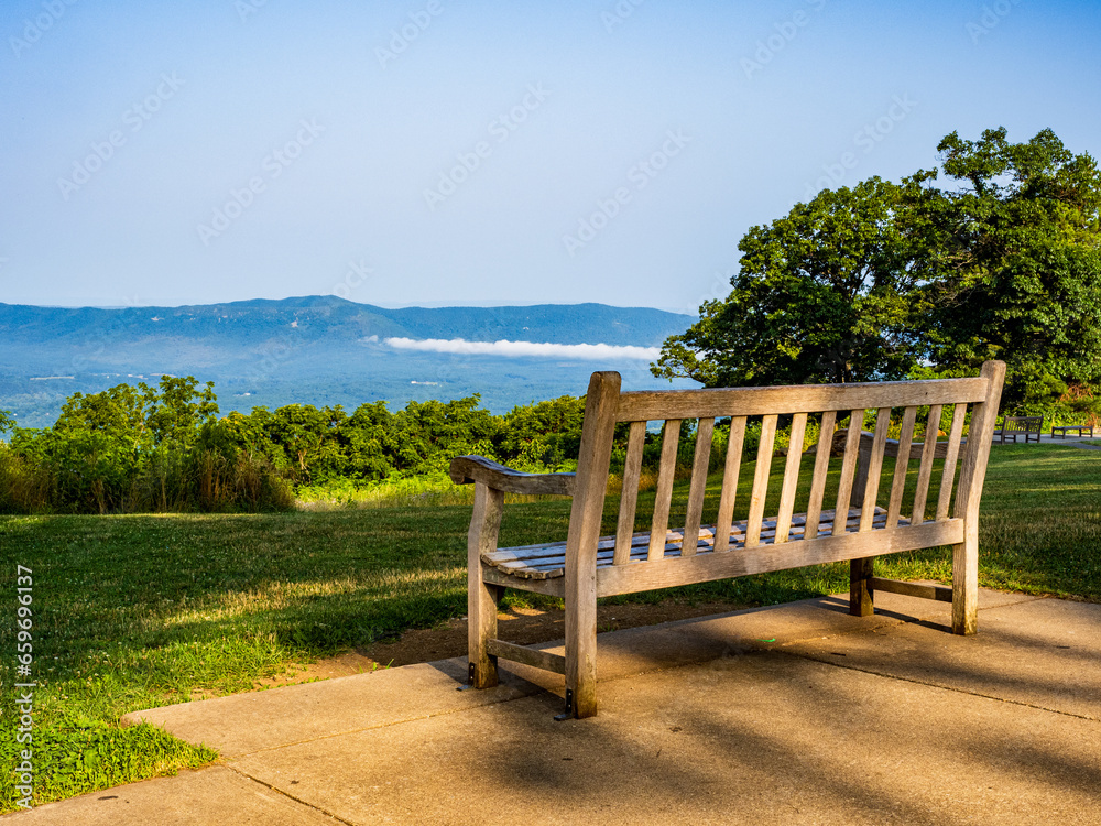 Bench lit by the setting sun overlooking the Shenandoah Valley at the Dickey Ridge Visitor Center in Shenandoah National Park, Virginia, USA. Bench lit by the setting sun overlooking the Shenandoah Valley at the Dickey Ridge Visitor Center in Shenandoah National Park, Virginia, USA.