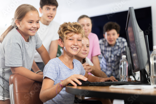 Classmates solve computer problem together in a school computer class