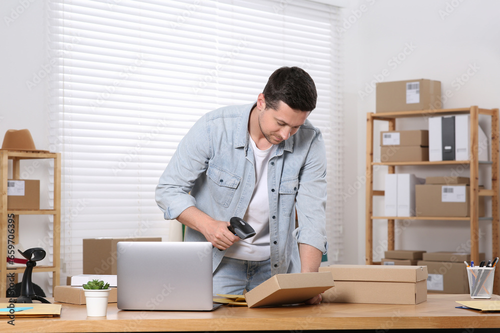 Seller with scanner reading parcel barcode in office. Online store Seller with scanner reading parcel barcode in office. Online store
