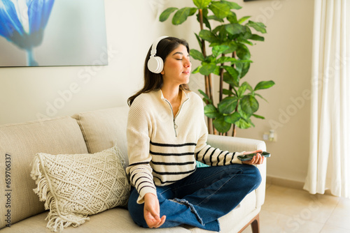 Relaxed woman practicing mindfulness meditation with headphones