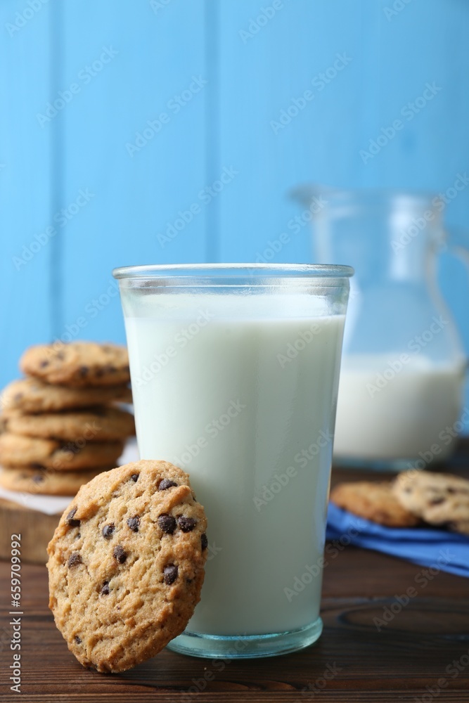 Delicious chocolate chip cookie and glass of milk on wooden table, closeup Delicious chocolate chip cookie and glass of milk on wooden table, closeup