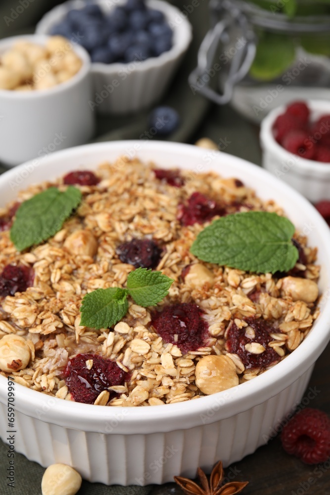 Tasty baked oatmeal with berries and nuts on wooden table, closeup Tasty baked oatmeal with berries and nuts on wooden table, closeup