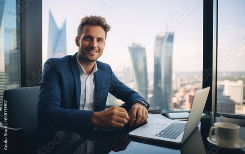 Successful startup CEO sitting at his desk with a laptop