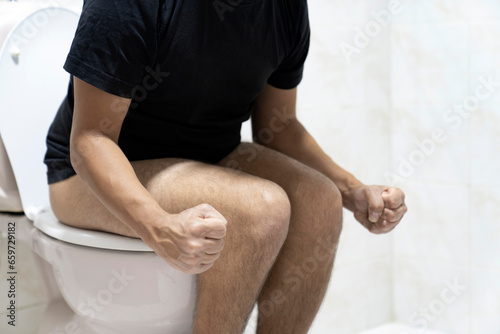 Sitting on toilet with suffering from constipation or hemorrhoid.  Feels uncomfortable in his stomach and is constipated in the toilet. suffering from diarrhea, cystitis. Stomach pain during PMS. photo