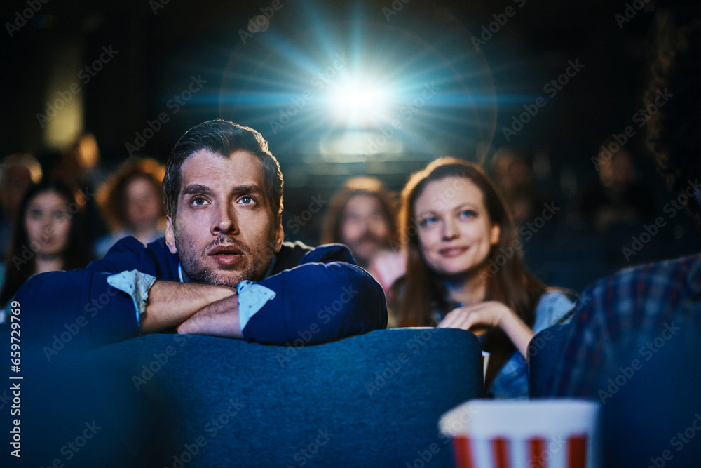 Young Caucasian man watching a movie in a movie theater Young Caucasian man watching a movie in a movie theater