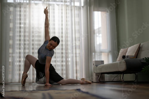 Fototapeta Naklejka Na Ścianę i Meble -  Young girl practicing ballet dancing in the living room. Young ballerina