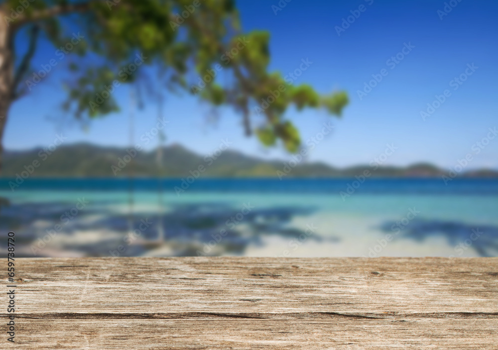 Fototapeta premium Wooden table top on the beach or sea.Party on the beach sunshine time concept.For montage product display or design key visual layout.View of copy space.