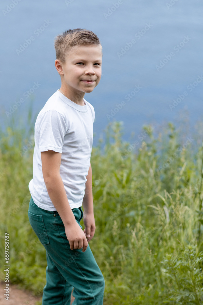 Father and son in white T-shirts walking, chatting on the riverbank on a sunny afternoon. High quality photo Father and son in white T-shirts walking, chatting on the riverbank on a sunny afternoon. High quality photo