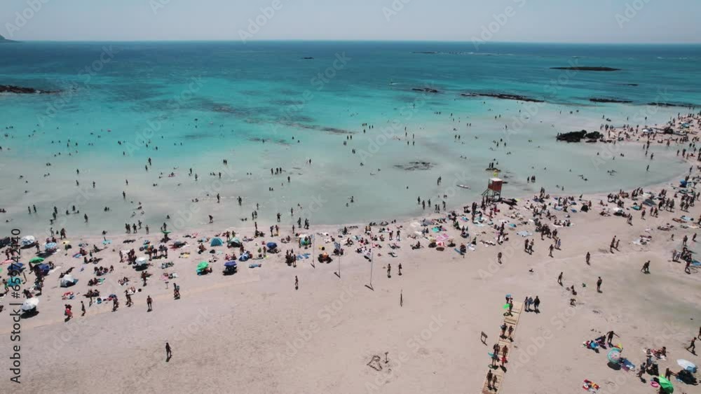 Drone flying over crowded Elafonisi Beach with crystal clear sea water on Crete island, Greece. High quality 4k footage Drone flying over crowded Elafonisi Beach with crystal clear sea water on Crete island, Greece. High quality 4k footage