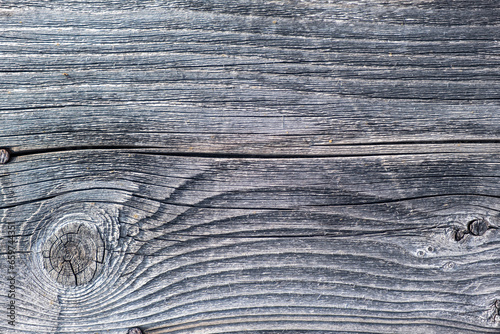 Elements of the walls of a wooden old village house. Wooden Log cabin walls texture. Weathered surface of an old wooden log house close-up. Old wooden log building in winter close-up.