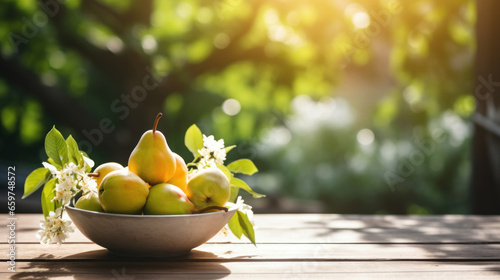 Pears in a ceramic bowl on a wooden table drenched in sunshine against a blurred garden backdrop