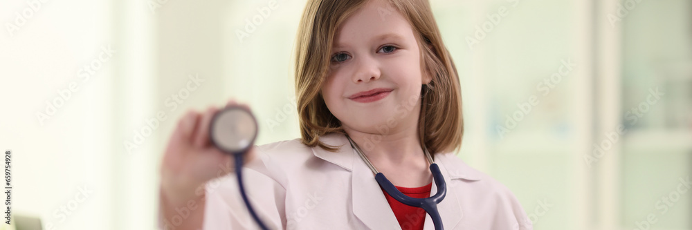 Cute blonde girl holds stethoscope ready to check patient Cute blonde girl holds stethoscope ready to check patient