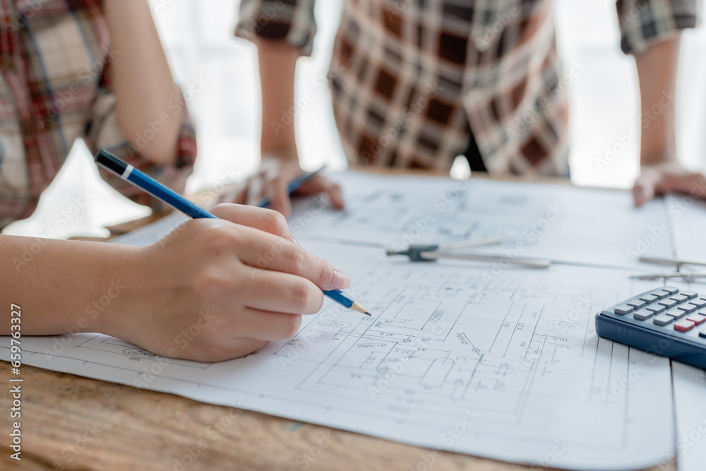 multi ethnic engineer brainstorming and measuring for cost estimating on blueprint and floor plan drawings about design architectural and engineering for houses and buildings