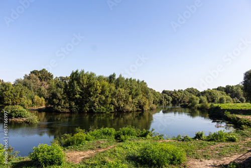 Landscape with river, trees and blue sky