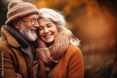 An elderly couple  a man and a woman  hugging in an autumn park. They look at each other with a loving gaze. Old people on a walk. Relationships in old age. Love and romance.