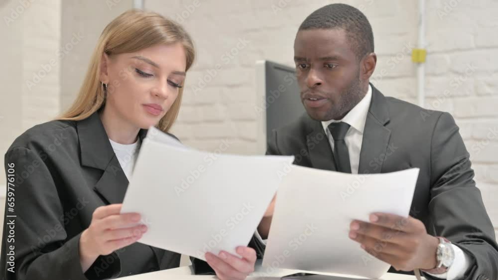 Businesswoman and African Businessman Discussing Business Report in Office Businesswoman and African Businessman Discussing Business Report in Office