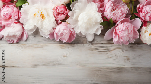 Decorative floral backgro, banner made of pink and white peonies flowers. Old grey wooden table background. Empty copy space. Flat lay, top view. Picture for blog. Summer wedding or birthday concept © Pixel Town
