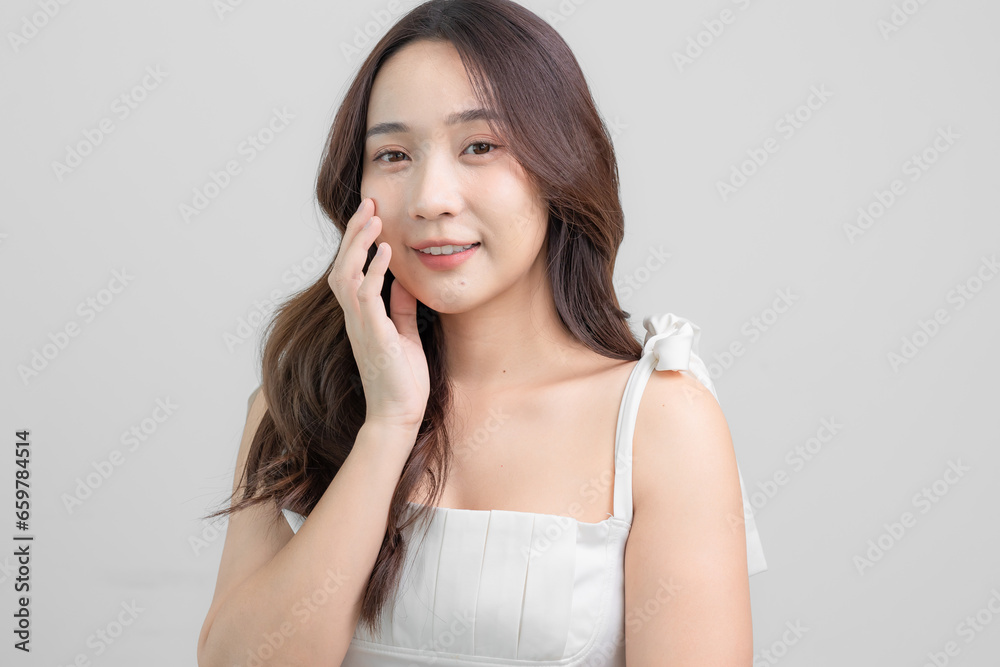 Asian woman taking care of her beautiful skin smiles at you with white background. Asian beauty Asian woman taking care of her beautiful skin smiles at you with white background. Asian beauty