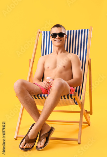 Teenage boy in deck chair o...