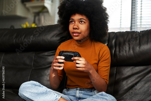 Teenage girl playing video game in the living room