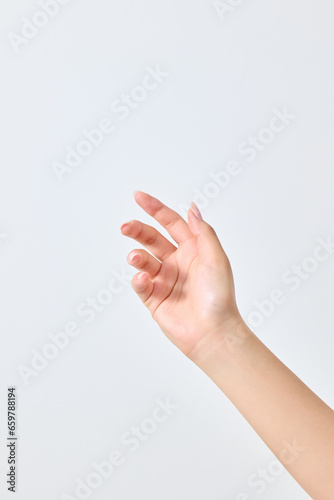 A asian woman's hand that appears to be holding a small cosmetic product.