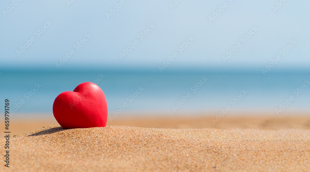 Red heart on a sandy beach. Romantic summer holiday by the sea Red heart on a sandy beach. Romantic summer holiday by the sea