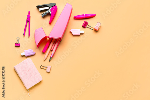 Fototapeta Naklejka Na Ścianę i Meble -  Pink pencil case with school stationery on beige background