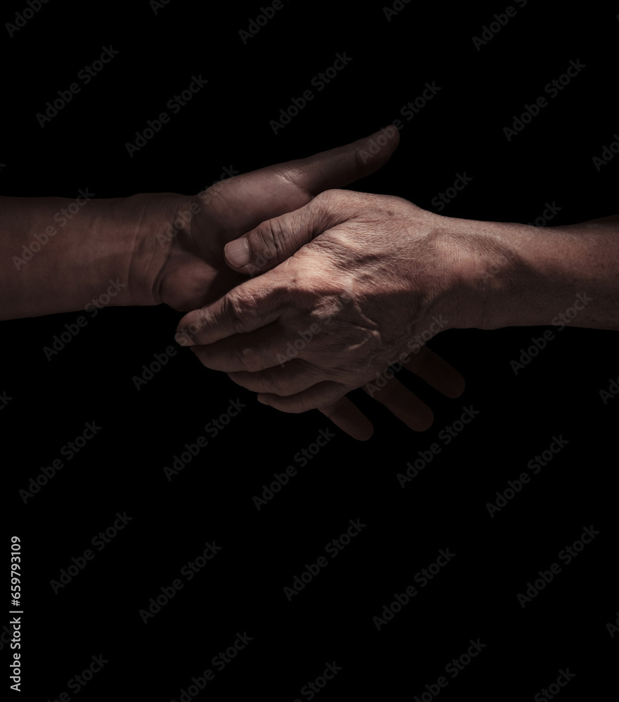 The old man holding hand with the young adult person. Family bonding concept. The caregiver makes elderly feel comfort and safe. Senior health care provider.