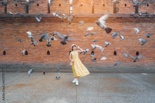 Canvas Print Young asian woman traveler in Yellow dress with hat and bag traveling on Tha Pae Gate, Tourist visit at the old city in Chang Mai, Thailand