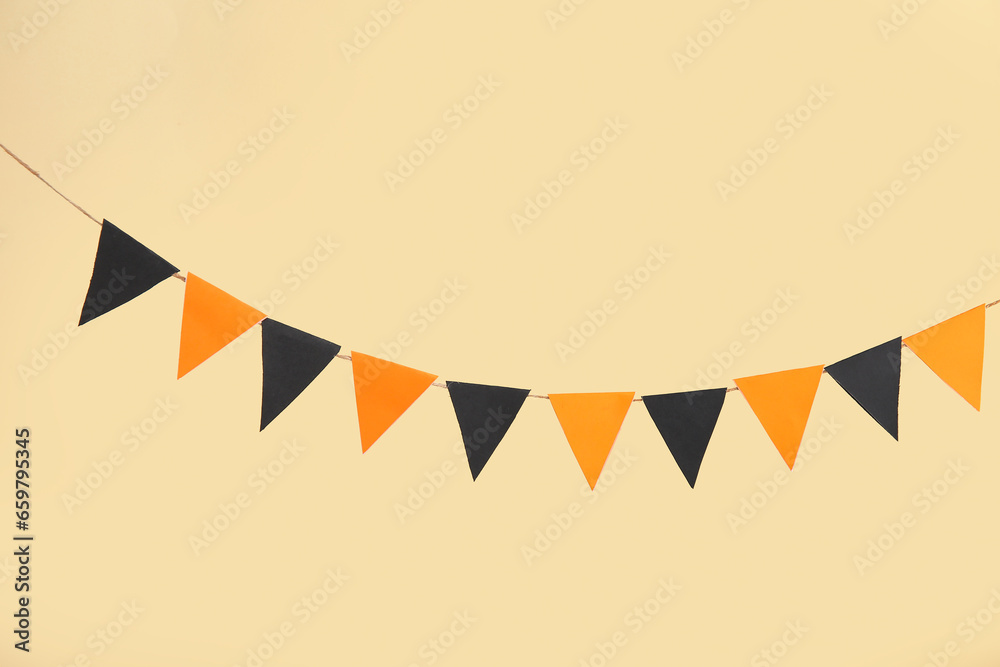 Obraz premium Garland made of paper flags for Halloween celebration on beige background