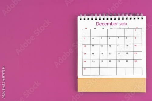 The December 2023, Monthly desk calendar for 2023 year on purple color background.