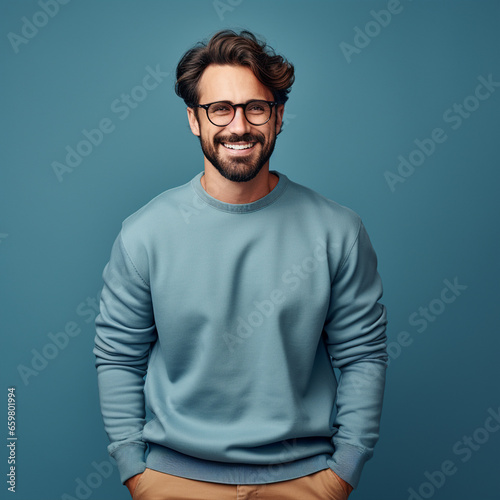 Young handsome man with beard wearing casual sweater and glasses over blue background, ai technology