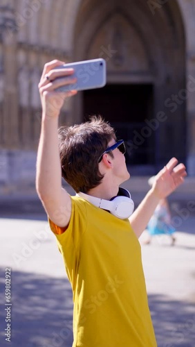 Young influencer live streaming on phone outdoors. Teenager boy showing travel destination