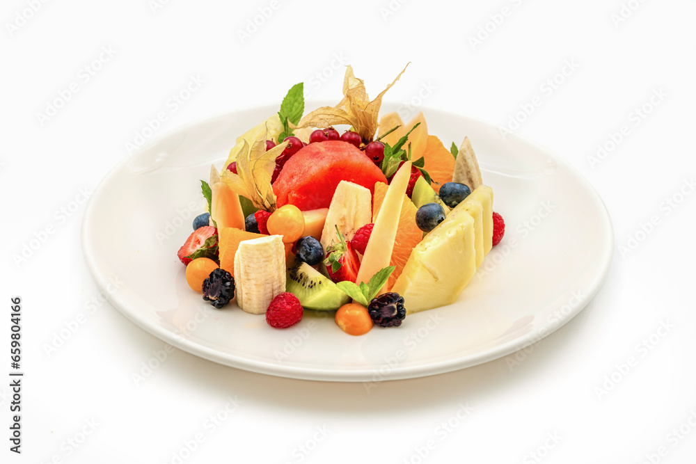 Mixed assorted fruits on white porcelain plate on wooden table Mixed assorted fruits on white porcelain plate on wooden table