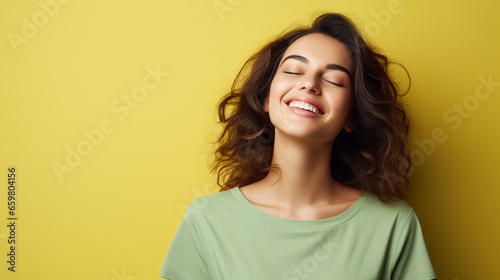 Portrait of a happy woman wearing green t-shirt in yellow background with copy space