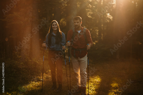 Pair of nature lovers with backpacks on a hiking adventure