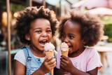 African american little girls eating ice cream in cone at cafe