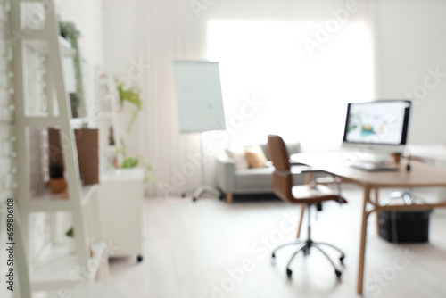 Blurred view of office with workplace and sofa