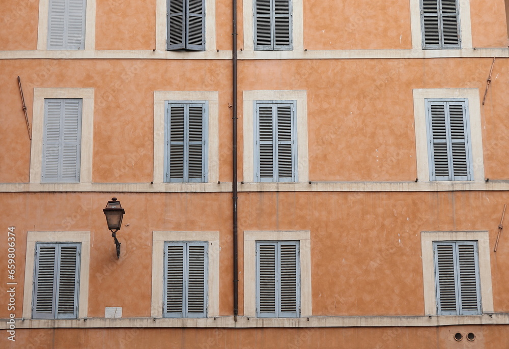 Traditional Building Facade with Windows and Wooden Shutters Close Up in Rome, Italy